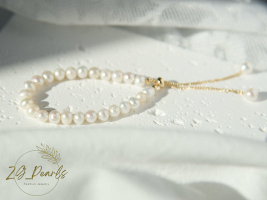 Pearl necklace on a white fabric background with 'ZG Pearls' branding.