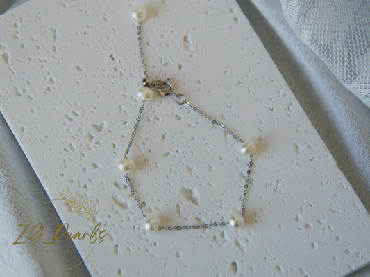 Pearl necklace on a textured white surface with '2g Pearls' branding.