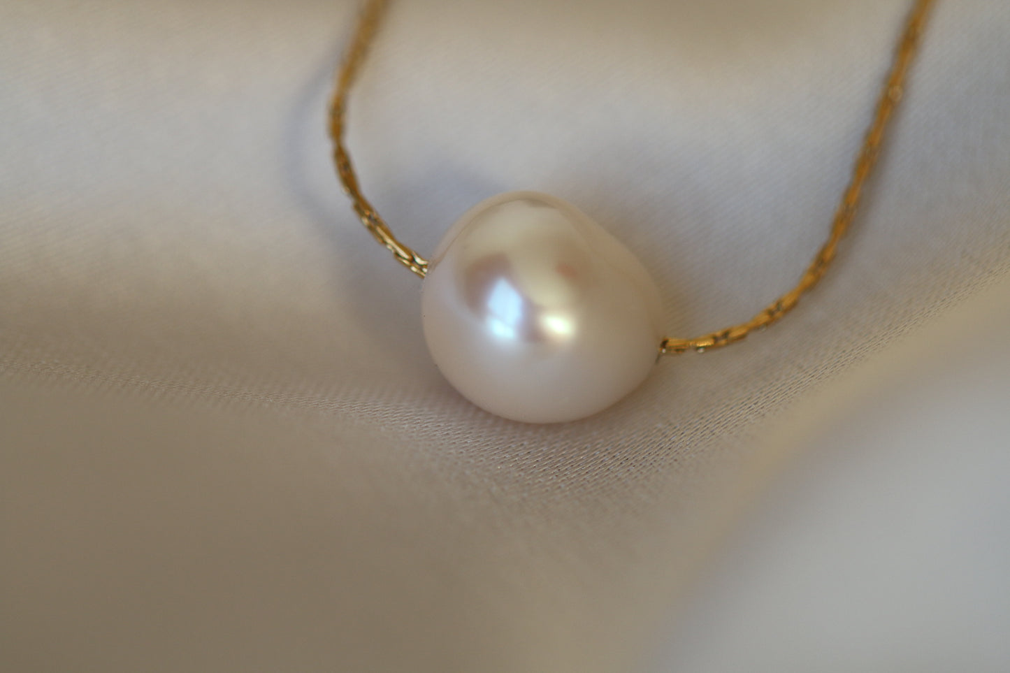 Pearl necklace on a soft fabric background