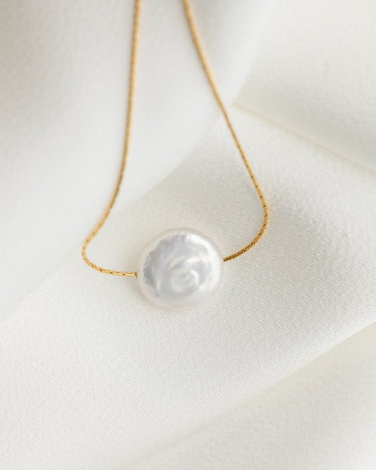 Pearl necklace on a white fabric background