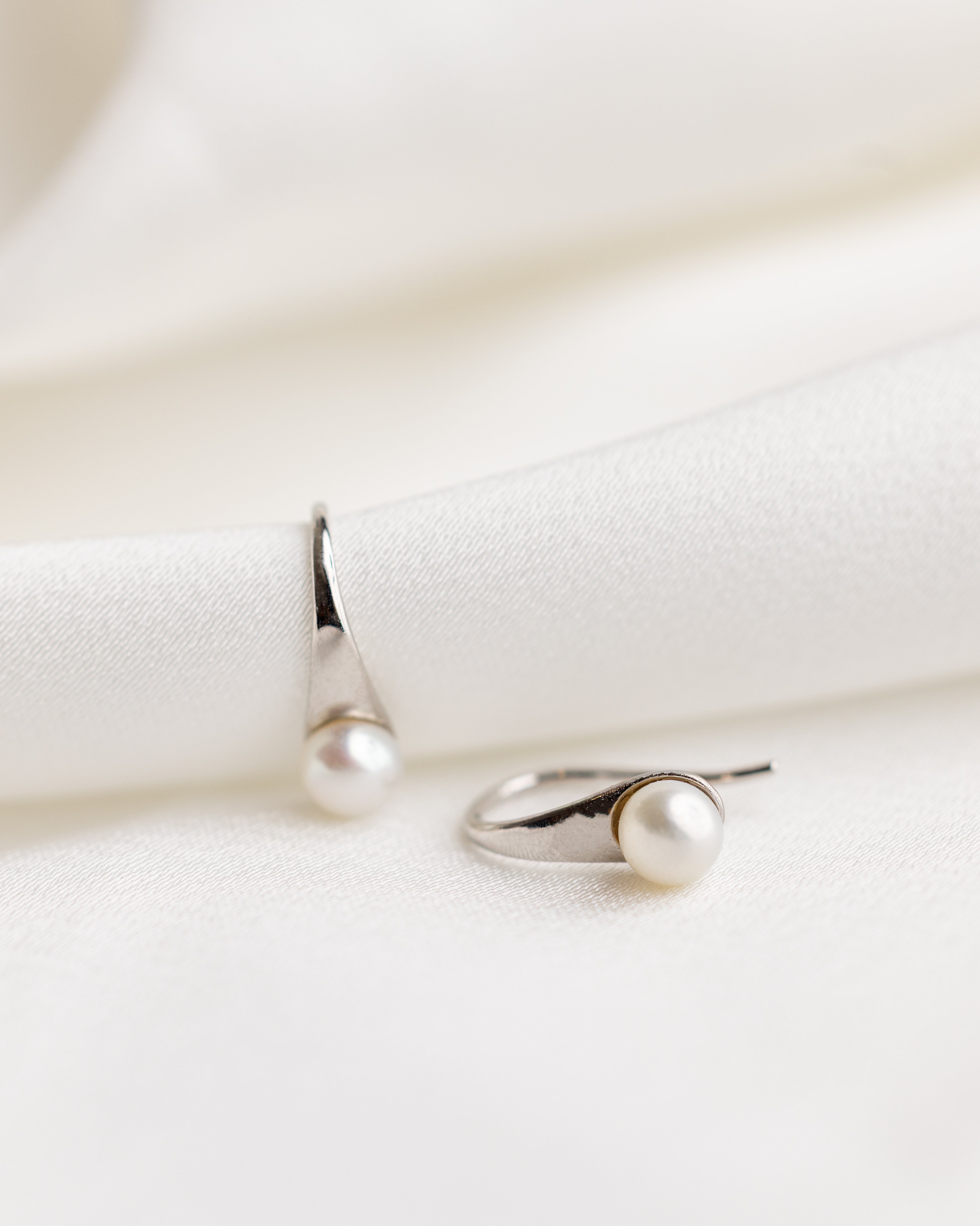 Pearl earrings on a white fabric background