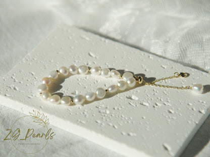 Pearl bracelet on a white textured surface with 'ZG Pearls' branding.