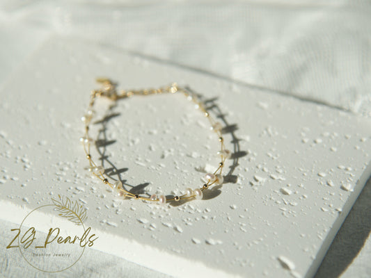 Gold bracelet with pearls on a light background, featuring the brand 'ZG Pearls'.