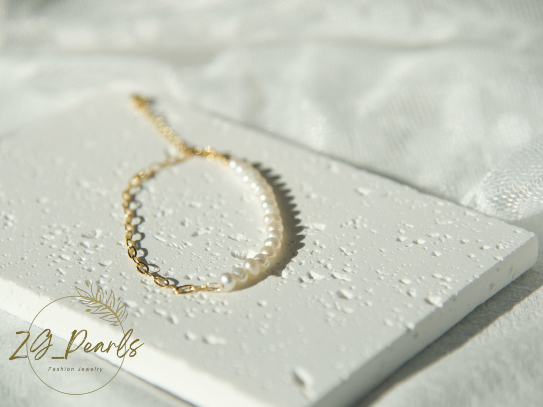Pearl bracelet on a textured white surface with 'ZL Pearls' branding.