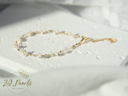 Gold and pearl bracelet on a white surface with 'ZG Pearls' branding.