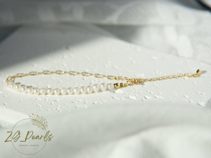 Gold chain necklace with pearls on a white fabric background, featuring the ZJ Pearls brand.