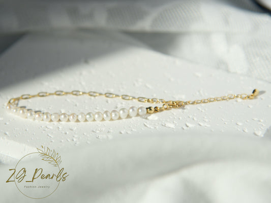 Gold chain necklace with pearls on a white fabric background, featuring the ZJ Pearls brand.