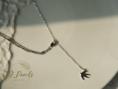 Necklace with a bird-shaped pendant on a neutral background, featuring the brand 'ZG Pearls'.