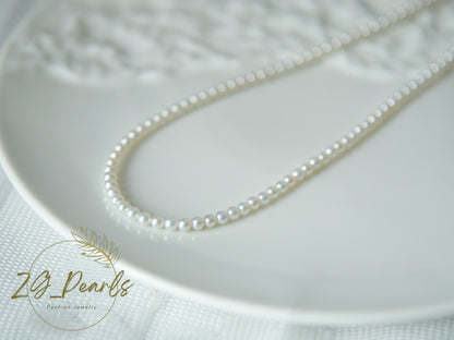 Pearl necklace on a textured white surface with 'ZG Pearls' branding.