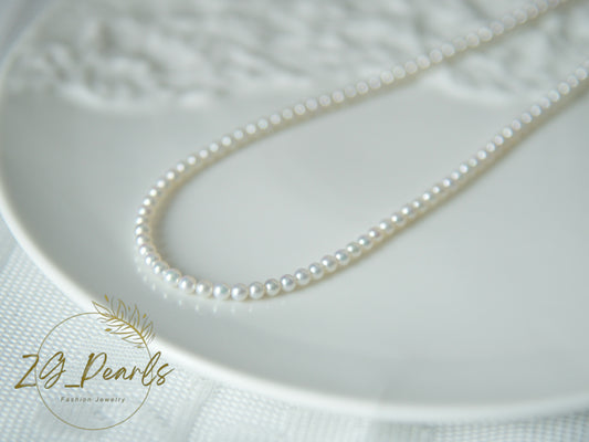 Pearl necklace on a textured white surface with 'ZG Pearls' branding.