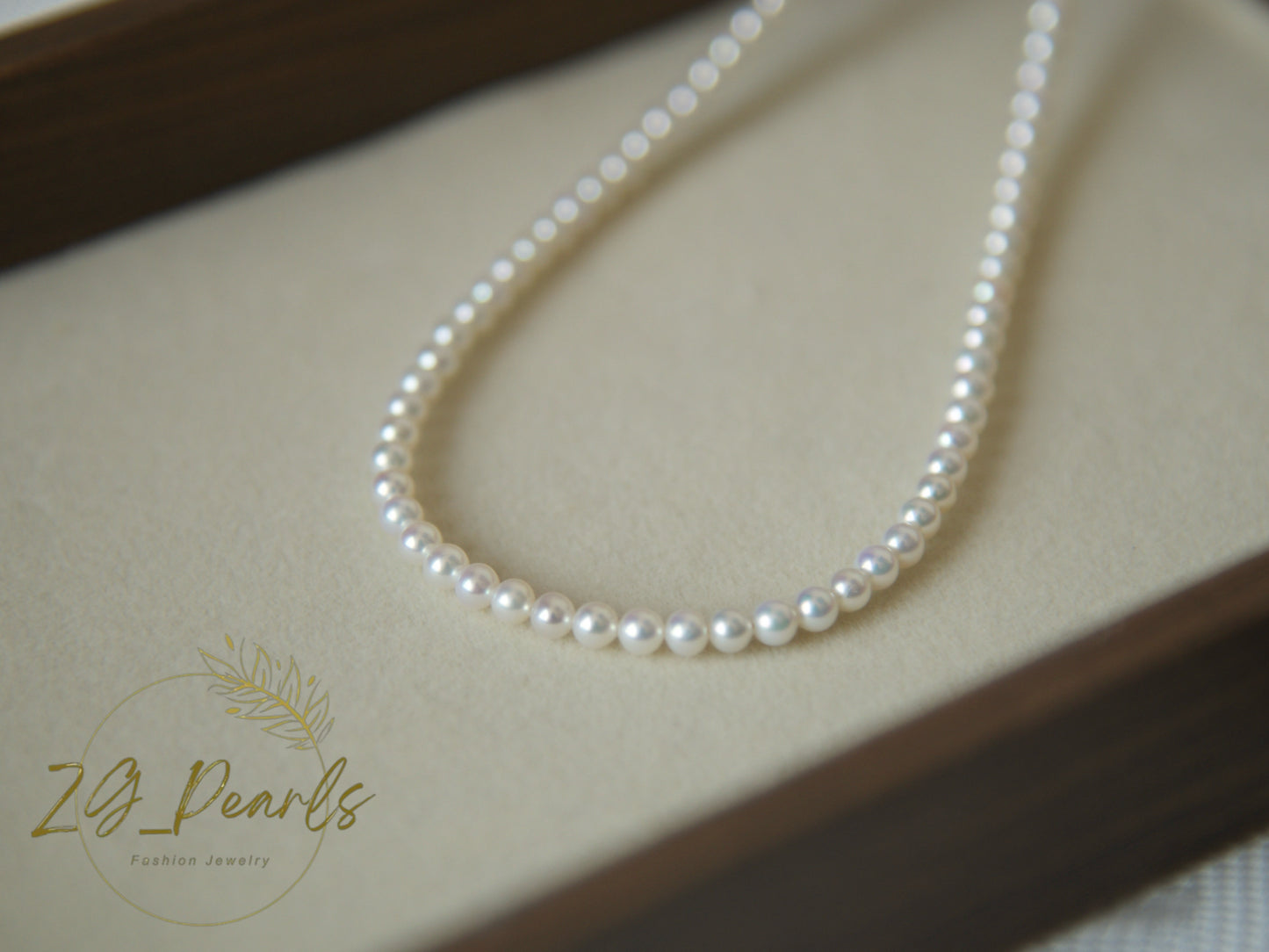 Pearl necklace on a beige surface with 'ZG Pearls' branding.