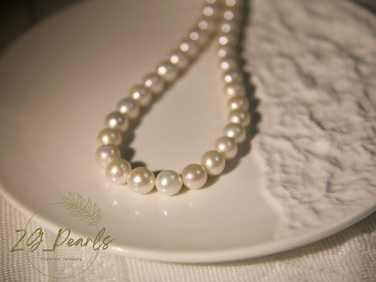 Pearl necklace on a textured white surface with 'ZG Pearls' branding.
