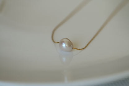 Pearl necklace on a white surface