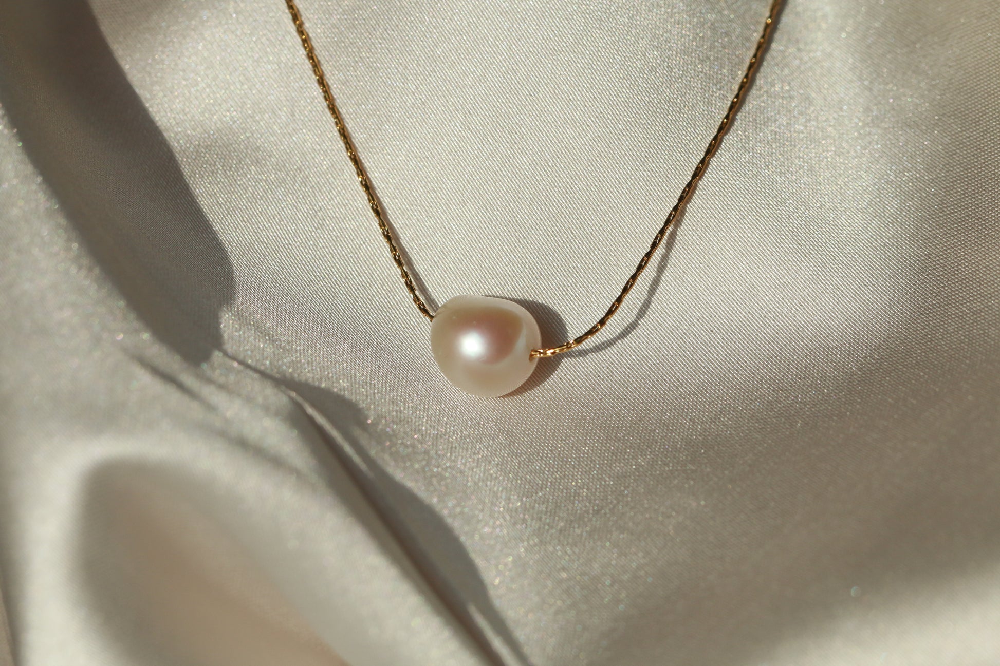 Pearl necklace on a light fabric background