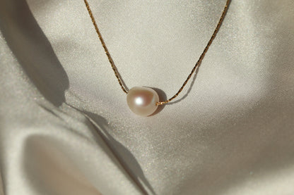 Pearl necklace on a light fabric background