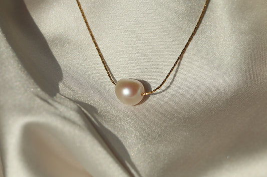 Pearl necklace on a light fabric background